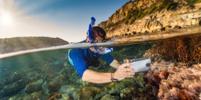 Člověk se potápí a má s sebou mobil ve vodotěsném obalu