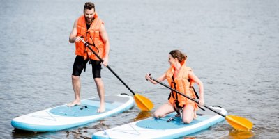 Muž a žena jedou na paddleboardech