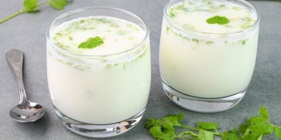 Dvě sklenice s podmáslím, vedle lžička a bylinky