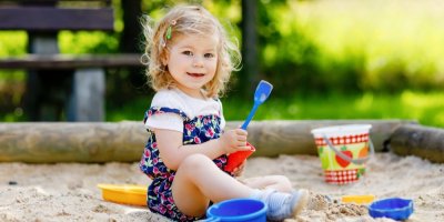 Malá holčička si hraje na pískovišti