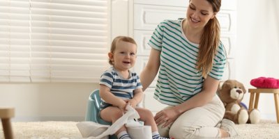 Dítě sedí na nočníku vedle matky