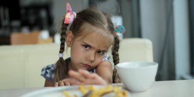 Holčička se tváří nemile na jídlo