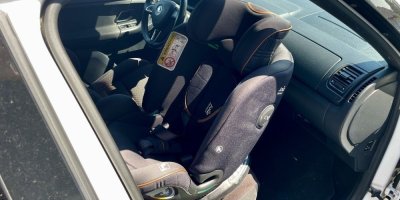 Dětská autosedačka umístěná na sedadle spolujezdce proti směru jízdy