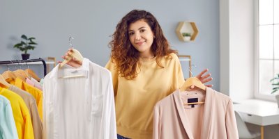 Žena drží sako a košili na ramínku