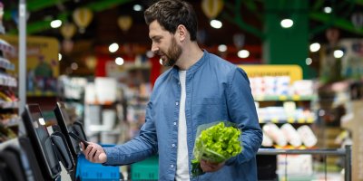 Muž platí u samoobslužné pokladny