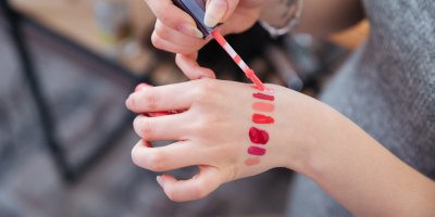 Žena zkouší rtěnku na ruce