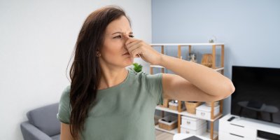 Žena si doma zacpává nos