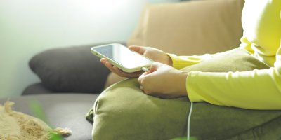 Žena dává nabíjecí kabel do mobilu