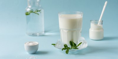 Bílý nápoj ve sklenice, okolo suroviny