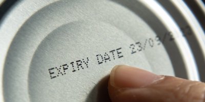 Prst ukazuje na datum spotřeby na konzervě