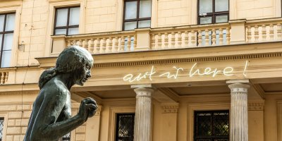 Nápis art is here a socha před historickou budovou