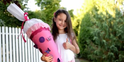 Holčička se usmívá a drží v ruce kornout