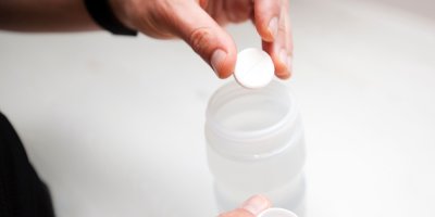 Člověk připravuje isotonický nápoj, vkládá šumivou tabletu do lahve