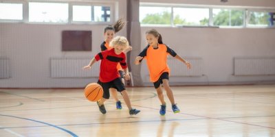 Děti hrají basketbal v tělocvičně