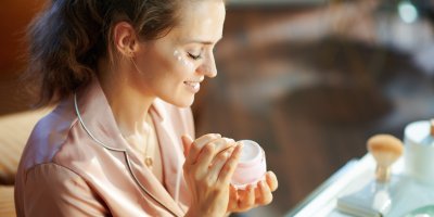 Žena si nanáší krém na obličej