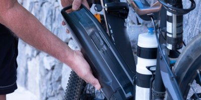 Muž drží baterii elektrokola