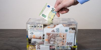 Přispívání do kasičky s penězi