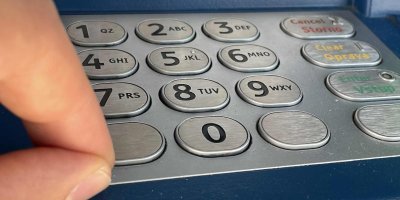 Detail prstů a číselné klávesnice bankomatu