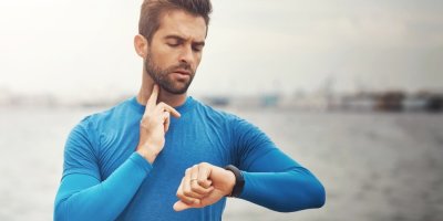 Muž ve sportovním oblečení si měří tepovou frekvenci