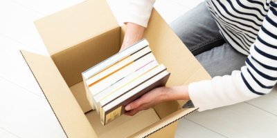 Žena vkládá knihy do krabice