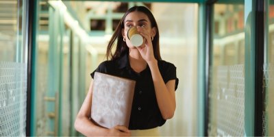 Žena pije kávu z kelímku