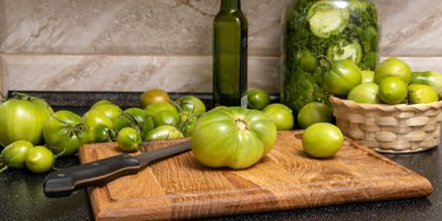 Nezralá zelená rajčata na dřevěném prkénku