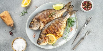 Dvě ugrilované ryby na talíři