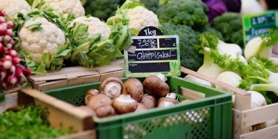 Bedýnka s žampiony na trhu, kolem květák, brokolice, ředkvička