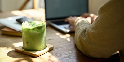 Matcha latte a žena pracující na notebooku