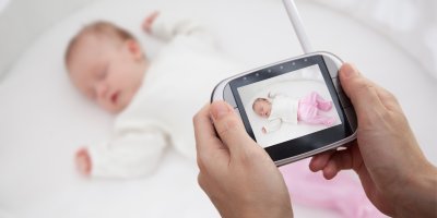 Ruce držící dětskou chůvičku nad dítětem