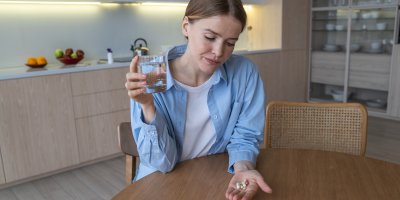 Žena s tabletkami v dlaních