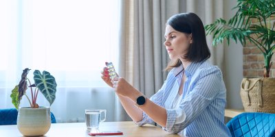 Žena drží v rukou platíčko s léky