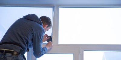 Muž instaluje okenní fólii