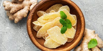 Kandovaný zázvor v dřevěné misce, čerstvý zázvor