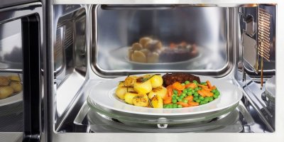 Maso s mrkví, hráškem a bramborami na talíři v mikrovlnce