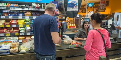 Lidé jsou u pokladny v obchodě