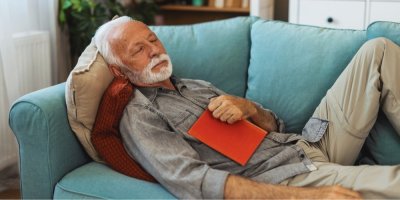 Starší muž spí na pohovce v obývacím pokoji