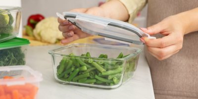 Žena ukládá zeleninu do skleněné dózy