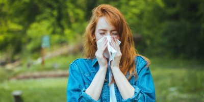 Žena je venku a smrká do kapesníku