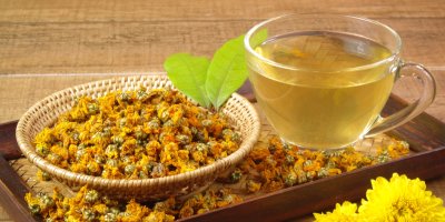 Čaj a vedle miska se sušenými květy