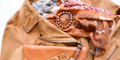 Dámská semišová bunda, šátek, kabelka a šperky v oranžových odstínech