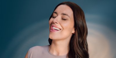 Žena si spokojeně kontroluje hladké zuby