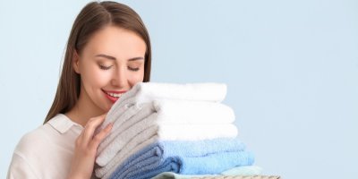 Žena se zavřenýma očima čichá k ručníkům 