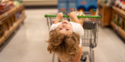 Dítě zavěšené na nákupním vozíku