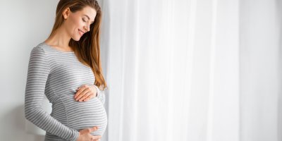 Těhotná žena si drží břicho