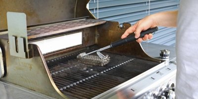 Muž čistí venkovní gril