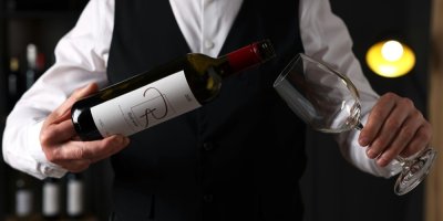 Someliér nalévá víno do sklenice