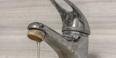 Voda tekoucí ze starého vodovodního kohoutku