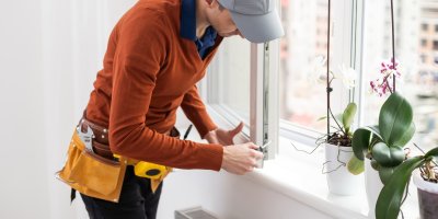 Montážník upravuje šrouby v okně