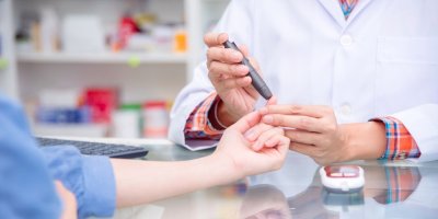 Farmaceut měří ženě hladinu cukru v krvi